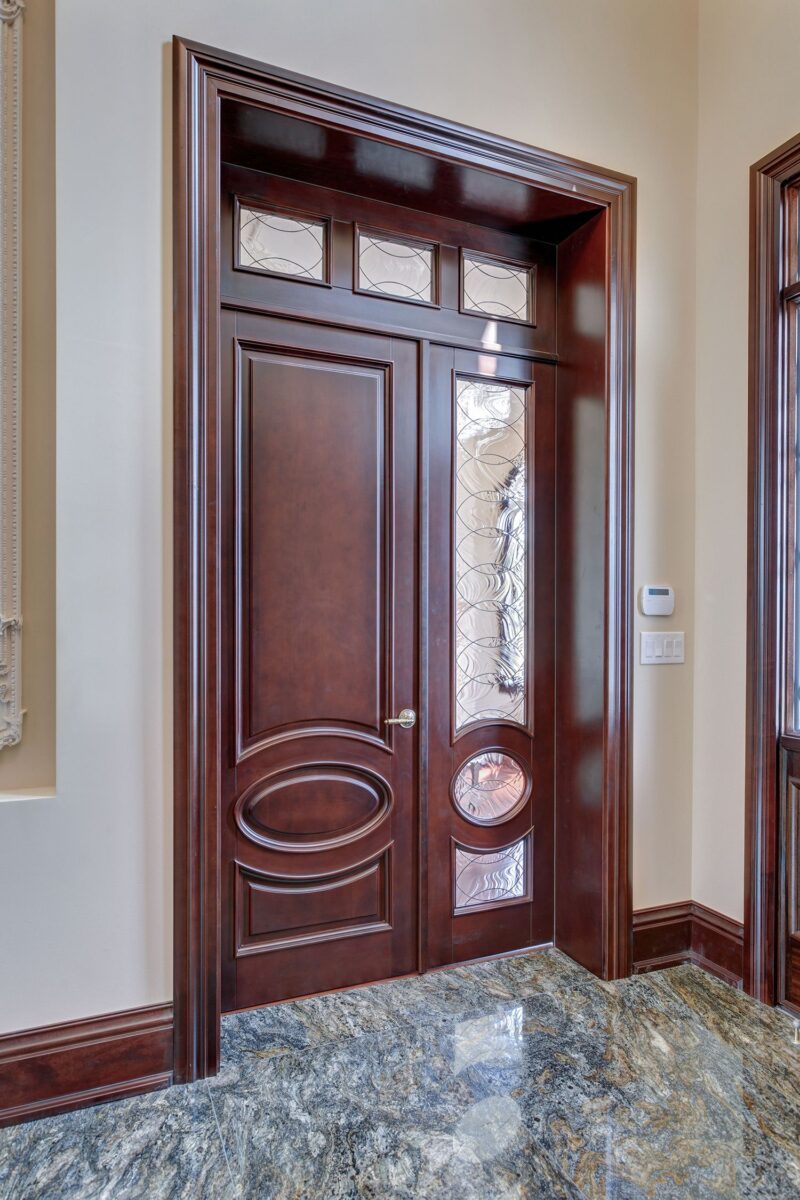 Entryway with dark wood door featuring the Door Glass Insert - Rio and marble flooring in bright natural light.