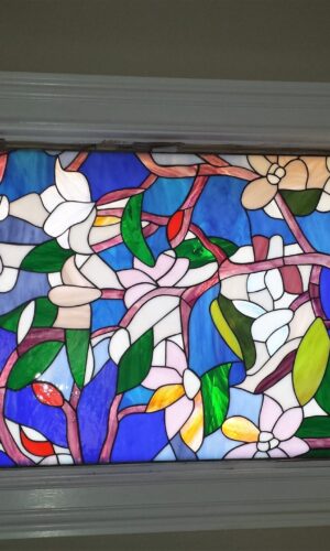 Floral Art Stained Glass Window with white and pink flowers, green leaves, blue background, and white trim.