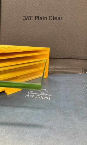 A 3/8″ Thick Plain Clear Glass Shelf is displayed on yellow, with text seen behind on the dark background.