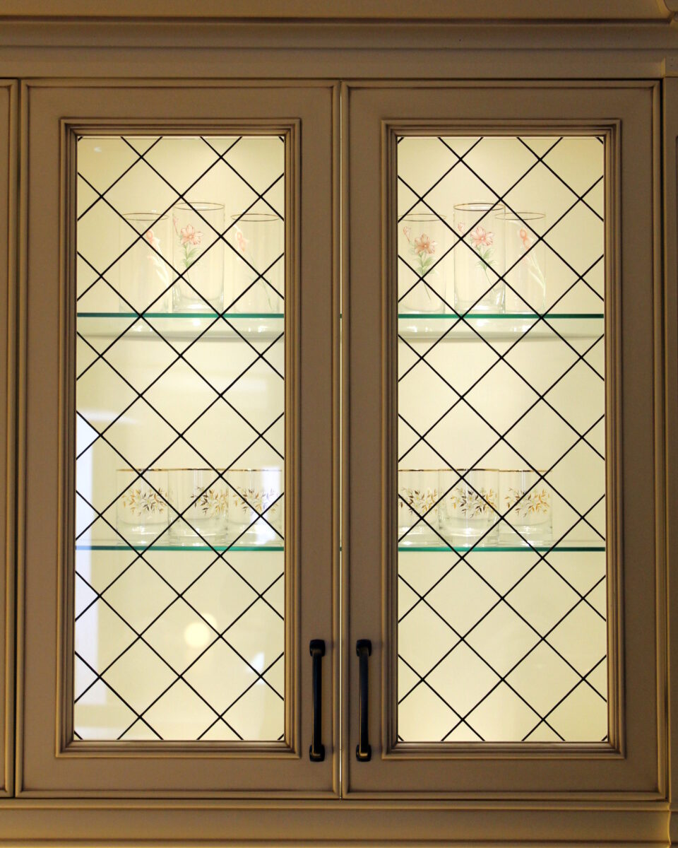 Apollo cabinet with diamond glass doors, floral glassware displayed on sleek interior glass shelves.