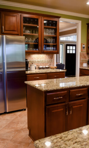 Modern kitchen with wood cabinets, granite counters, and a Frank Lloyd Wright stained glass door insert.