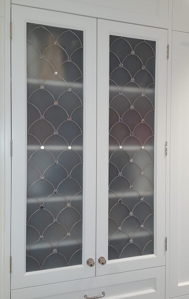 Venezzia: White cabinet with art glass on frosted doors, diamond lattice, and stylish metal handles.