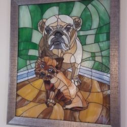 Stained glass artwork depicting a bulldog and a small brown dog on a green and brown abstract background.