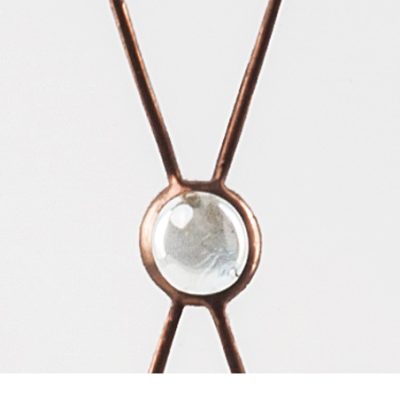 Close-up of a metal wire intersection with a clear round bead at the center, against a plain white background.