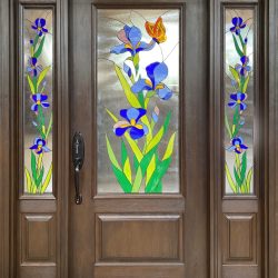 Stained glass door with blue irises, green leaves, and an orange butterfly on a wooden frame.