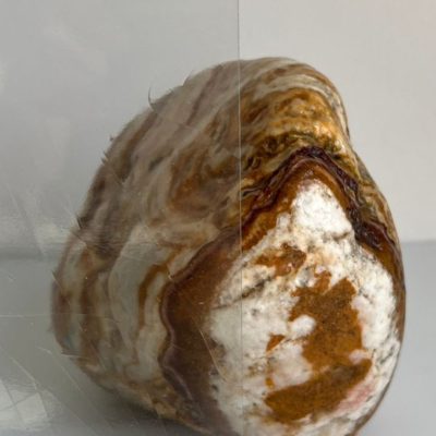 A brown and white rock is shown behind a transparent sheet, with the right half labeled “Casa Loma Anti Gloss.”.