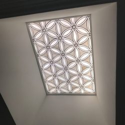 Rectangular ceiling light with geometric floral pattern, set in a recessed white ceiling.